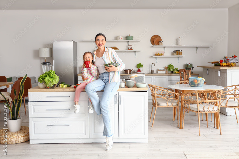 Little girl with her mother and healthy salad in kitchen Little girl with her mother and healthy salad in kitchen