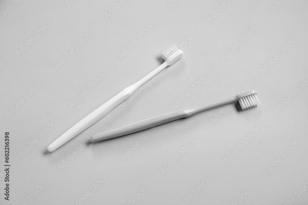 Plastic toothbrushes on grey background Plastic toothbrushes on grey background