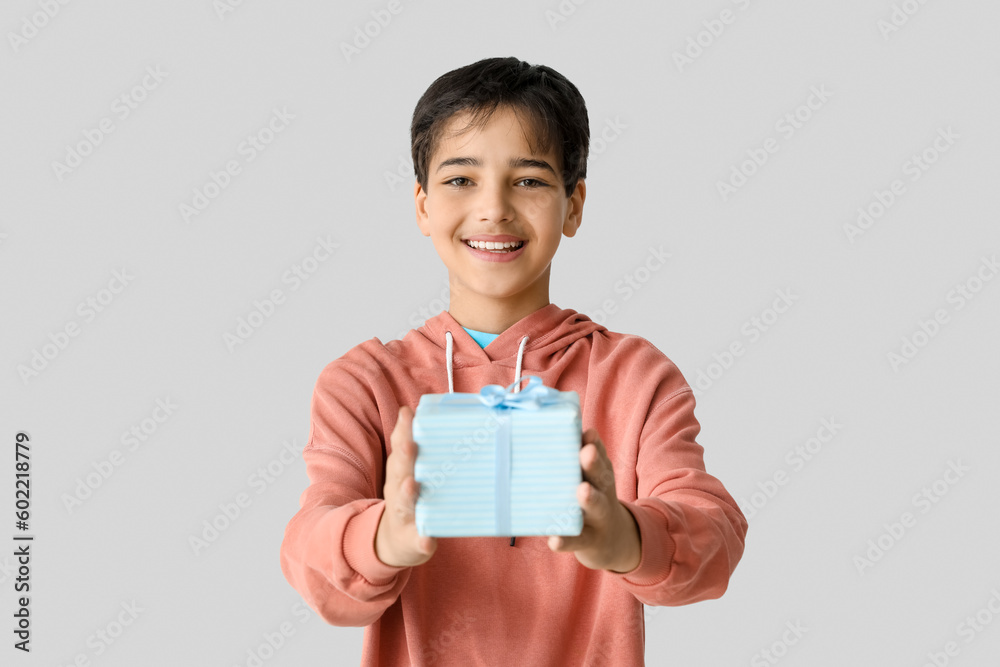 Little boy with gift on light background. Children's Day celebration Little boy with gift on light background. Children's Day celebration