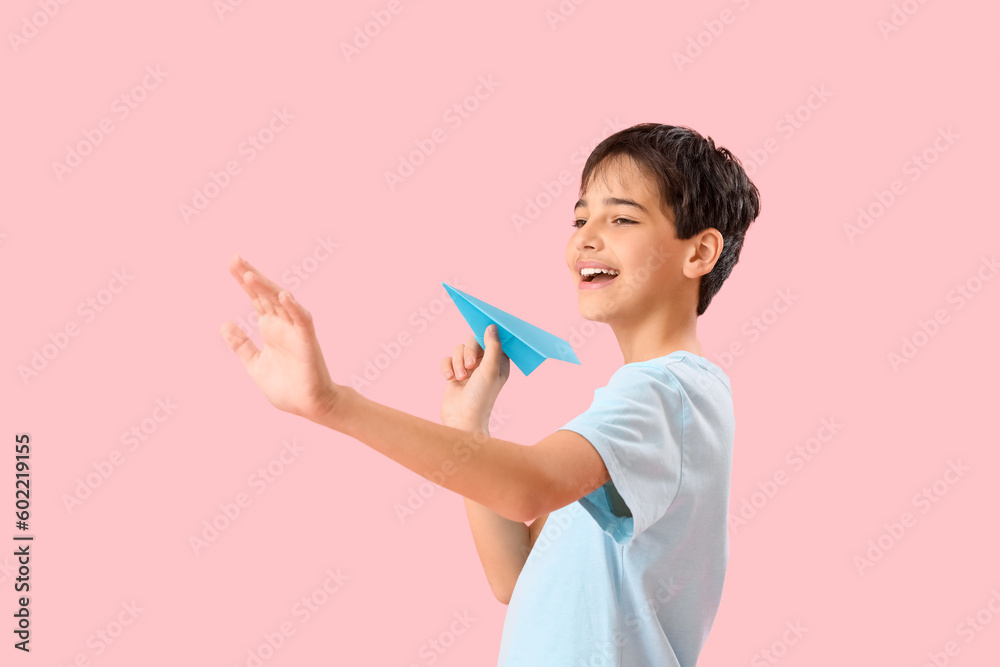 Little boy with paper plane on pink background. Children's Day celebration Little boy with paper plane on pink background. Children's Day celebration