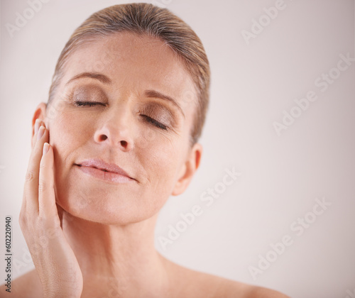 Face, beauty and mockup with a mature woman in studio on a mockup background for natural antiaging treatment. Facial, skincare and wellness with an attractive elderly female model touching her cheek