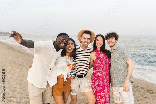 Portrait of Happy multiracial friends having fun outdoors on the beach in summer