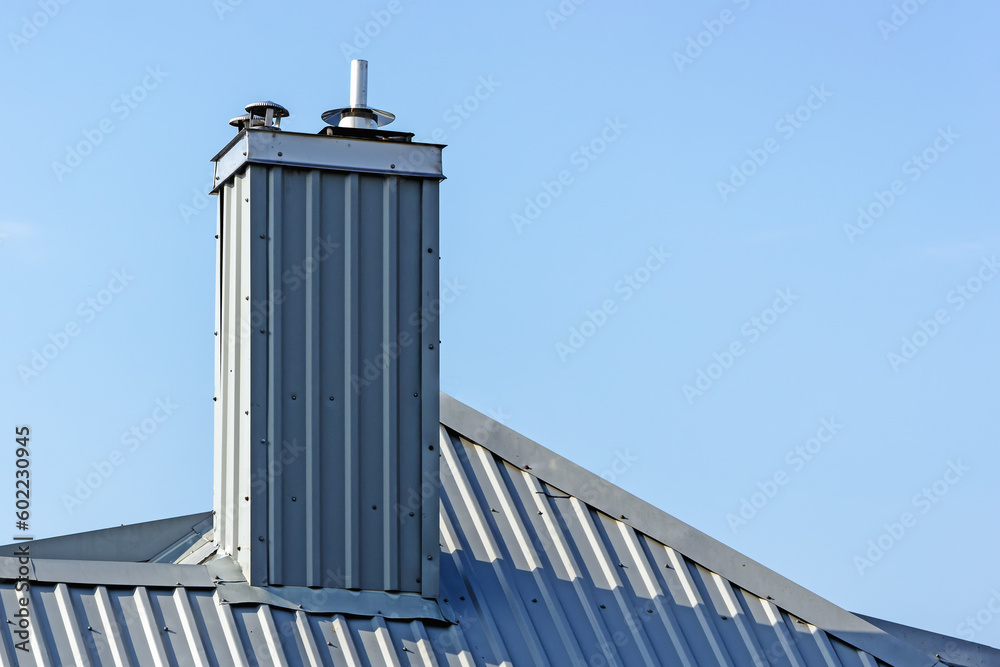 Obraz premium A tinned chimney with a metal insert on the background of the sky