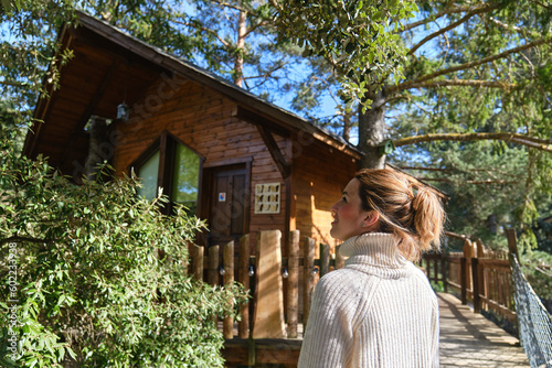 happy woman enjoying nature in a treehouse in the middle of the forest