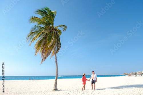 Eagle Beach Aruba  Palm Trees on the shoreline of Eagle Beach in Aruba  a couple of man  and woman on the beach of Aruba