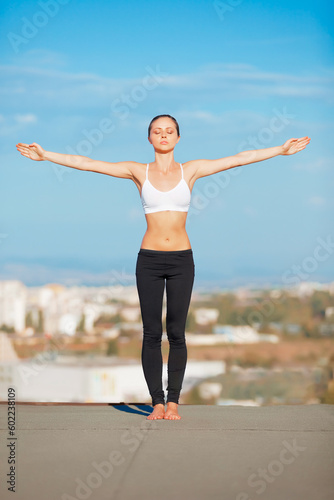 Calm woman, yoga and open arms on roof top in exercise, zen workout or fitness outdoors. Female yogi in warm up stretch or pose for healthy body, spiritual wellness or balanced mind outside town