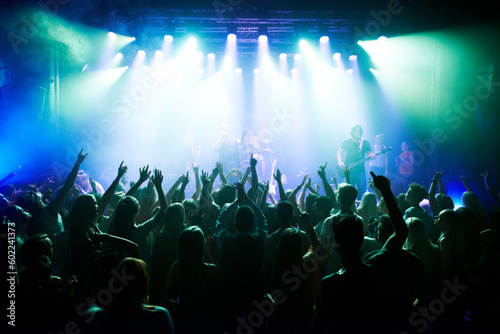 Music, dance and party with crowd at concert for rock, live band performance and festival show. New year, celebration and disco with audience of fans listening to techno, rave and nightclub event