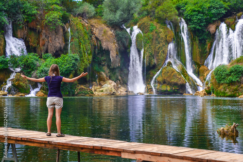 A girl standing in front of Kravica waterfalls in Bosnia and Hercegovina 