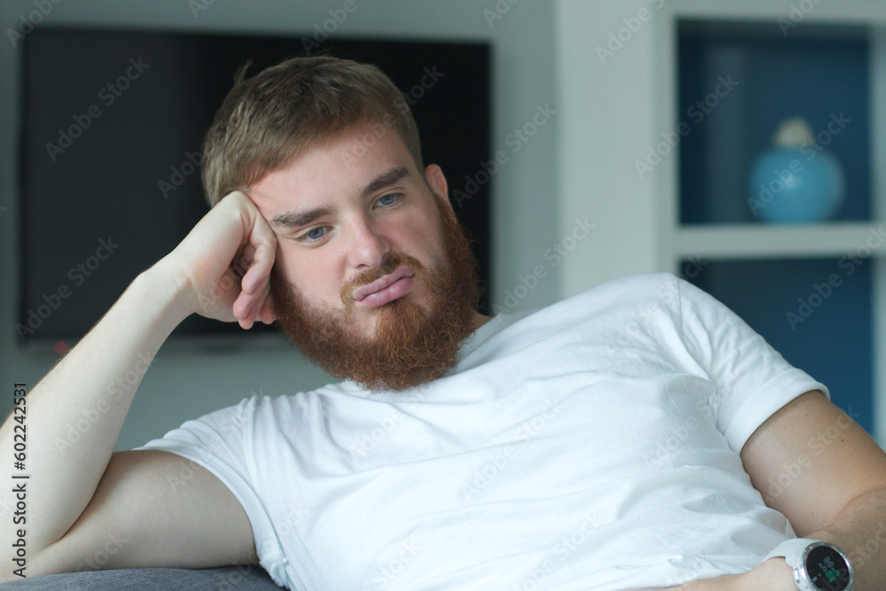Depressed unhappy middle-aged sad man sitting on couch in living room, leaning on his hands, having troubles loneliness, home interior, holding his forehead while having a headache Depressed unhappy middle-aged sad man sitting on couch in living room, leaning on his hands, having troubles loneliness, home interior, holding his forehead while having a headache