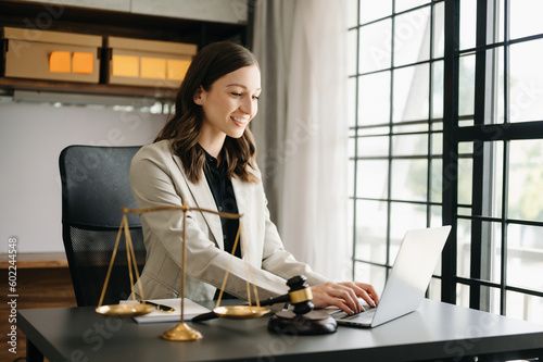 Beautiful Caucasian woman lawyer working and gavel, tablet, laptop in front, Advice justice and law concept. in office