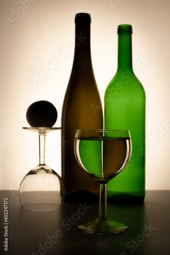 A bottle of wine and a glass are sitting on a table.