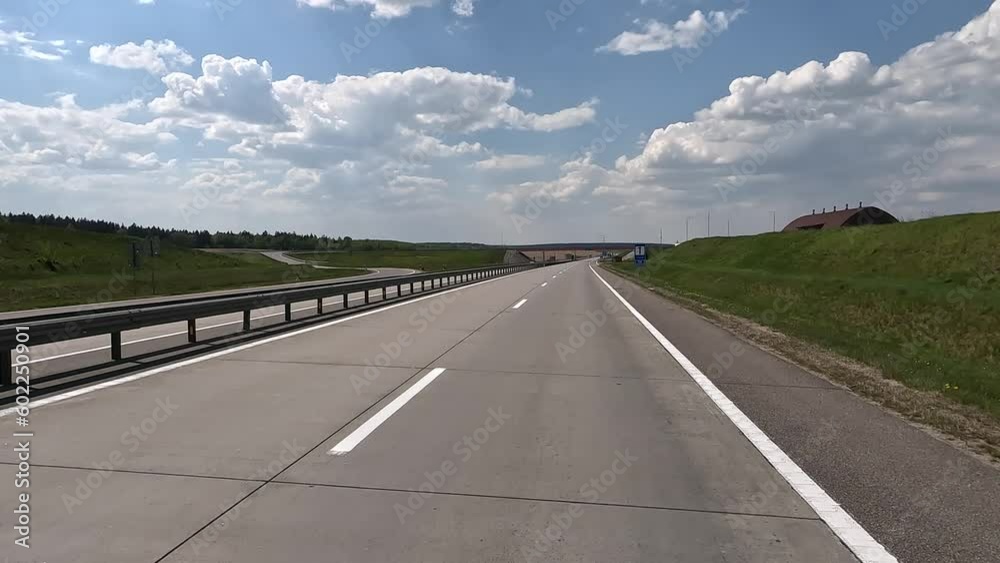 The car drives along the road on a summer day. Highways, roadside and road line markings. The car drives along the road on a summer day. Highways, roadside and road line markings.