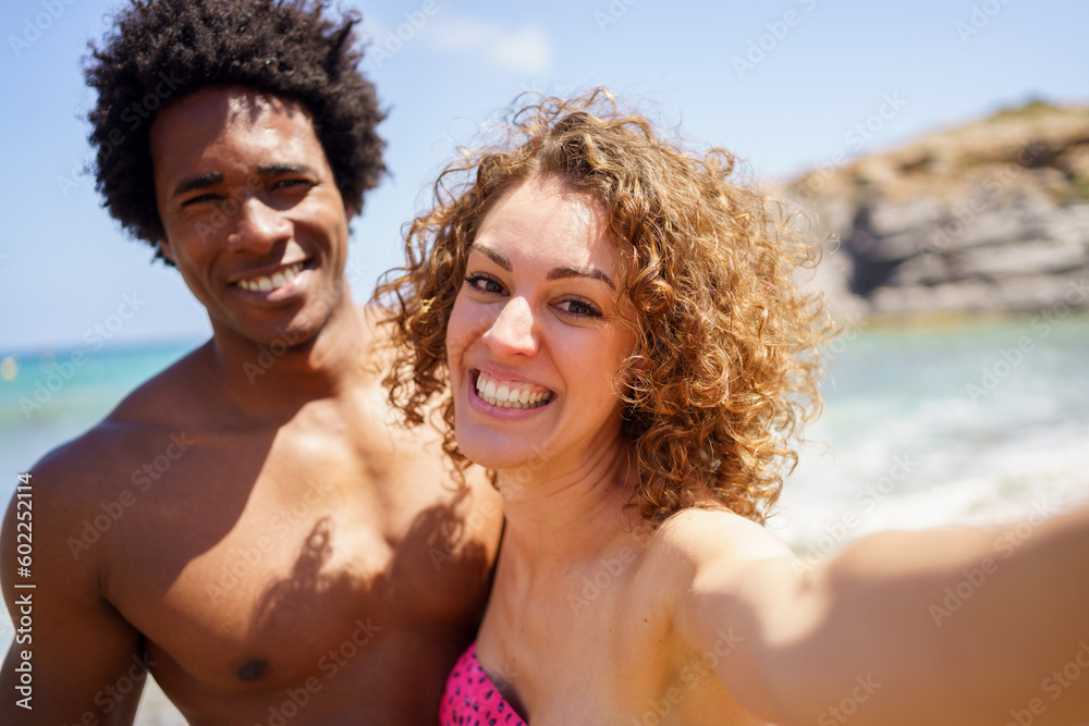 Content diverse couple taking selfie on coast of sea Content diverse couple taking selfie on coast of sea