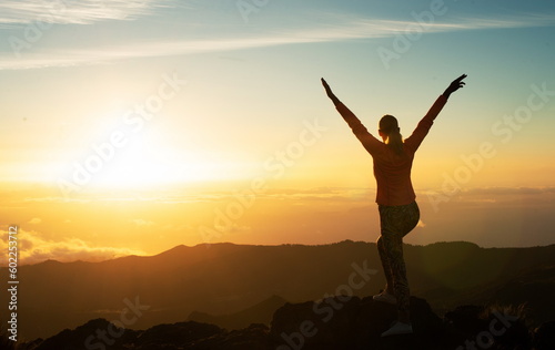Woman Standing On Top Of Mountain Raising Arms, Back View