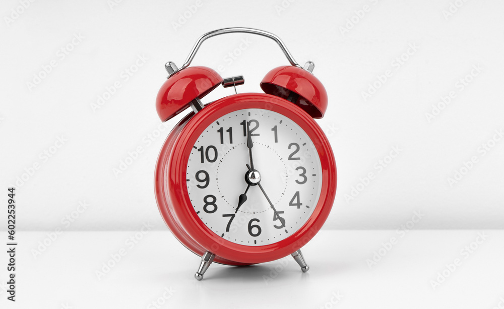 Red alarm clock on white wall background Red alarm clock on white wall background
