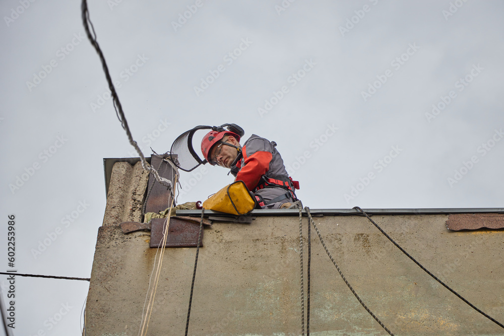 Rope access is a high-risk job. A man works on ropes.