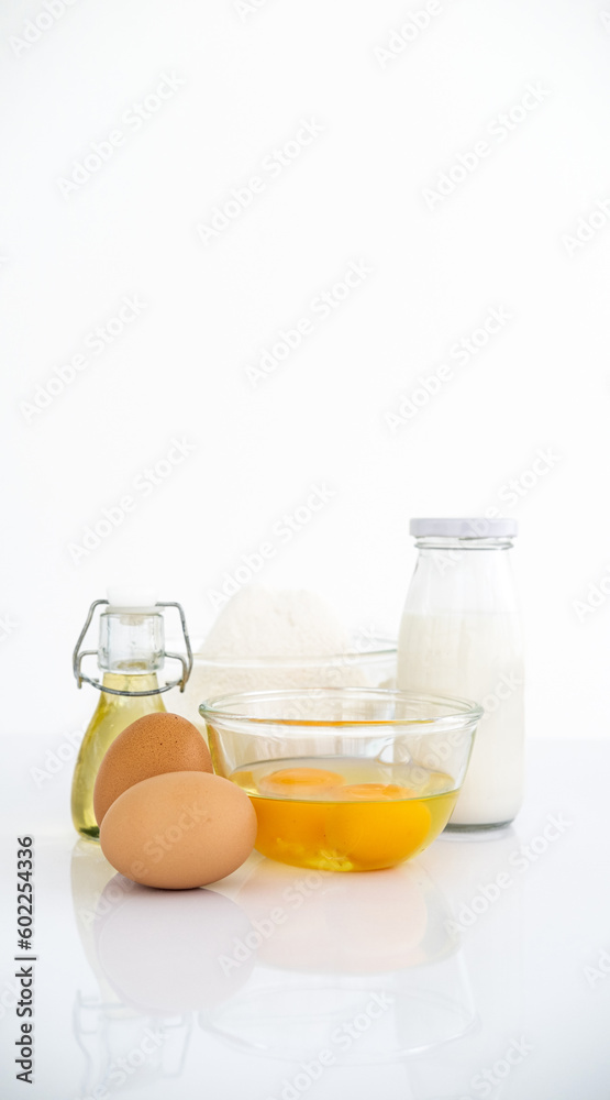Food ingredients on the table, milk oil eggs and flour. Front View Copy Space. Cookies Pie Or Cake Recipe Mockup Food ingredients on the table, milk oil eggs and flour. Front View Copy Space. Cookies Pie Or Cake Recipe Mockup