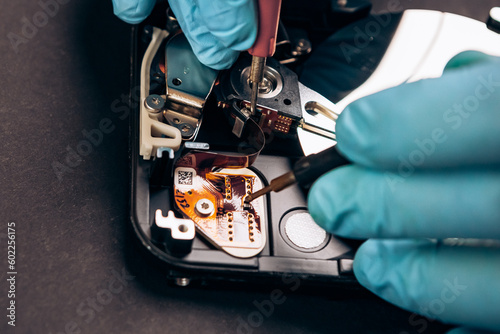 Computer service engineer technician workplace repairing fixing disassembled HDD hard drive data disc SSD, using multimeter ammeter. Recovery, maintenance work, access file. Profession repairman

