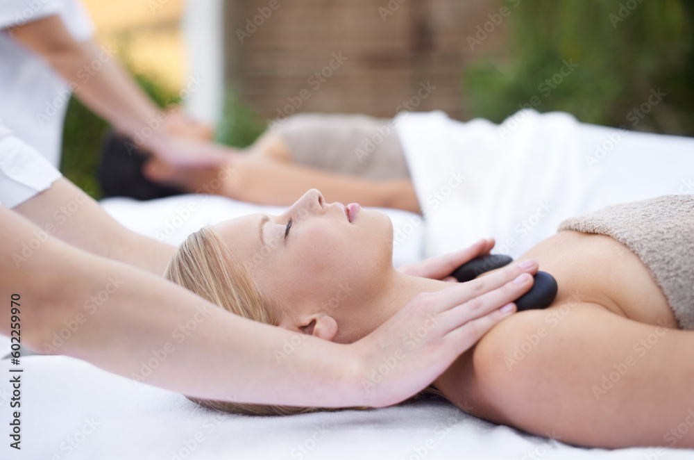 Woman at spa, hot stone massage and hands of masseuse, healing holistic treatment with zen at wellness resort. Rocks on body, peace and calm with physical therapy, alternative medicine and self care