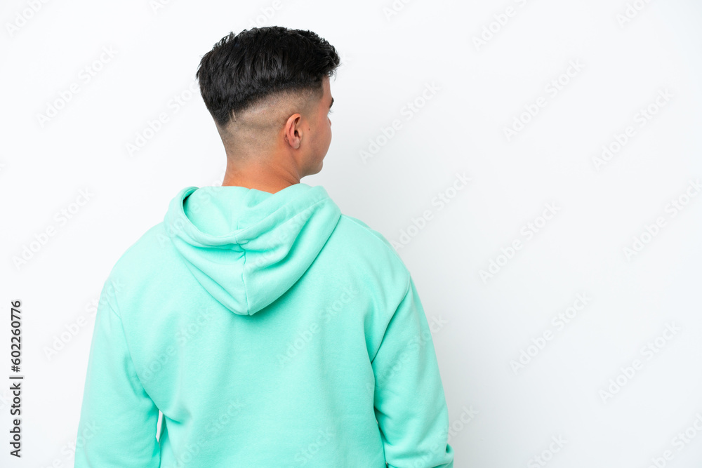 Young caucasian handsome man isolated on white background in back position and looking side Young caucasian handsome man isolated on white background in back position and looking side