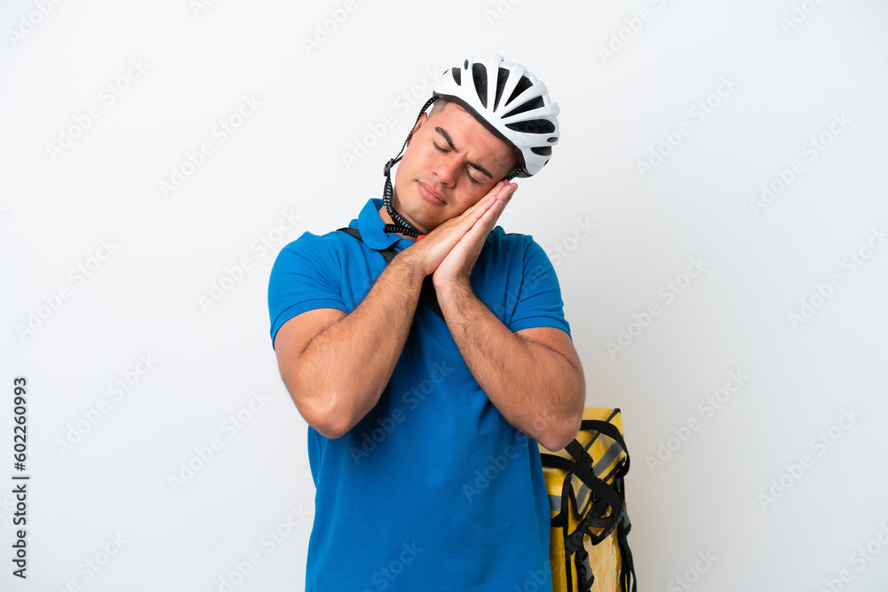 Young caucasian man with thermal backpack isolated on white background making sleep gesture in dorable expression Young caucasian man with thermal backpack isolated on white background making sleep gesture in dorable expression