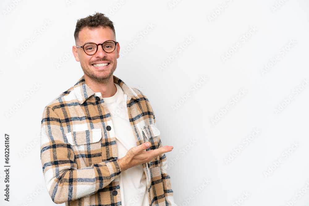 Young caucasian handsome man isolated on white background presenting an idea while looking smiling towards Young caucasian handsome man isolated on white background presenting an idea while looking smiling towards