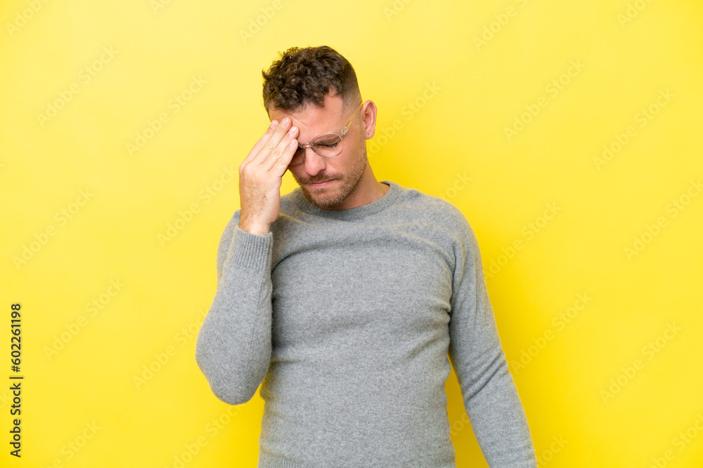 Young caucasian handsome man isolated on yellow background with headache Young caucasian handsome man isolated on yellow background with headache