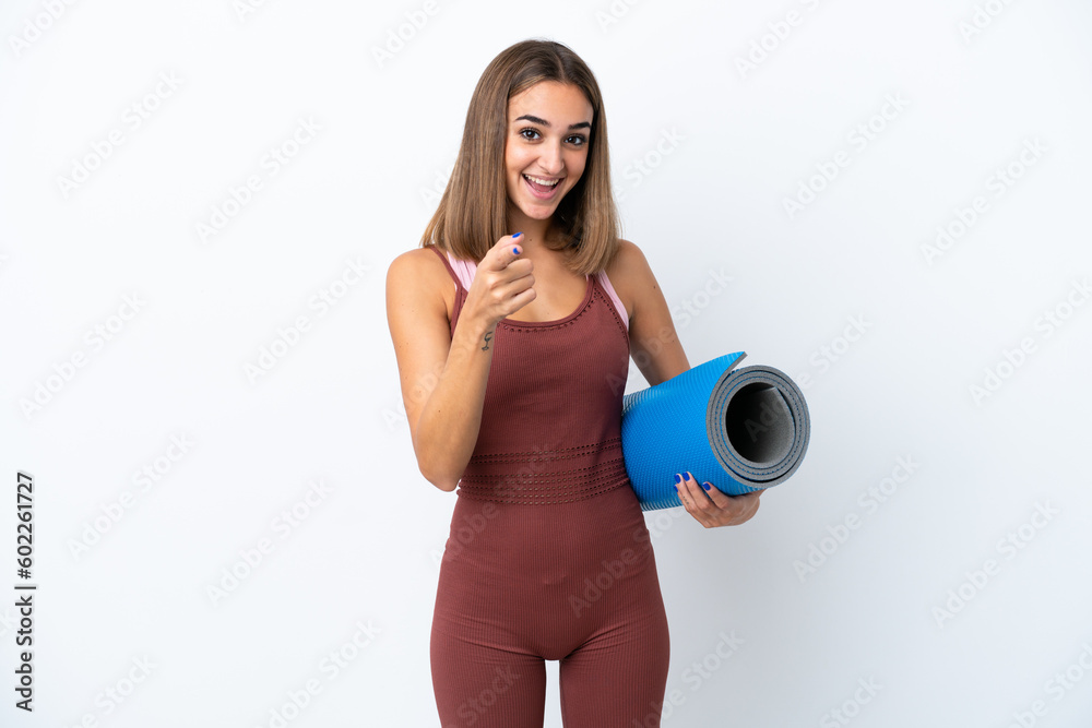 Young sport caucasian woman going to yoga classes isolated on white background surprised and pointing front Young sport caucasian woman going to yoga classes isolated on white background surprised and pointing front