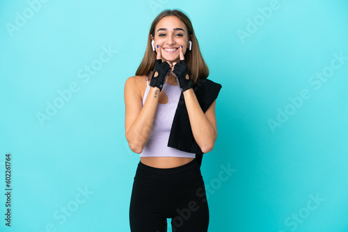 Young sport woman isolated on blue background smiling with a happy and pleasant expression