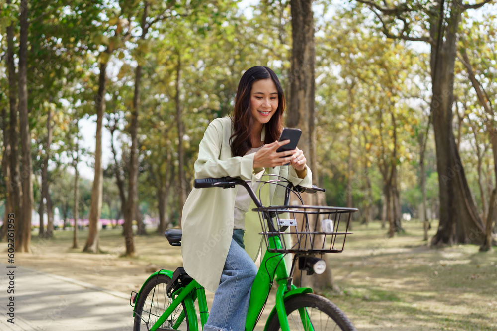 Women using smartphone to chatting and surfing social media after cycling for exercise in the park Women using smartphone to chatting and surfing social media after cycling for exercise in the park