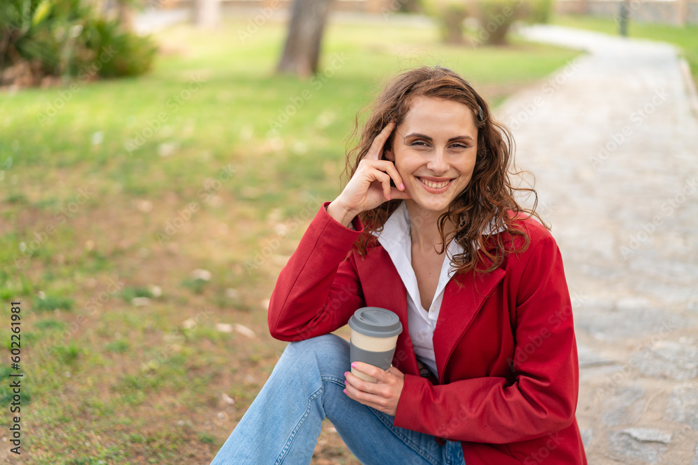 Young caucasian woman at outdoors holding a take away coffee Young caucasian woman at outdoors holding a take away coffee