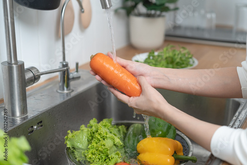 people washing raw vegetables at sink in the kitchen prepare ingredient for cooking