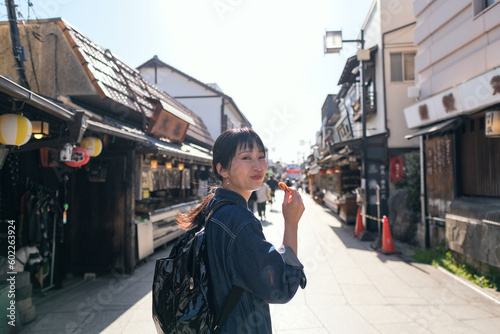 柴又の観光地で食べ歩きをする女性