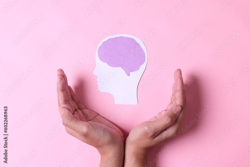 Hands with brain paper cutout isolated on pink background. World mental health day.  - obrazy, fototapety, plakaty 