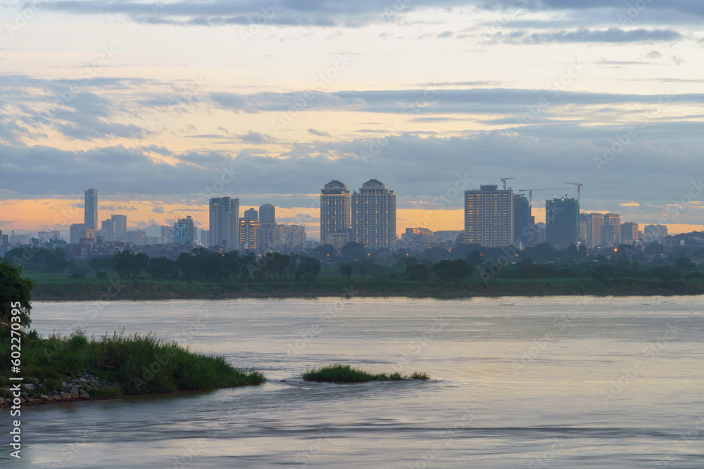 Red River (song Hong) landscape at sunset with Nhat Tan bridge on background in Hanoi, Vietnam