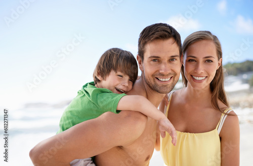Beach, summer and portrait of a family on vacation, travel or fun trip with a smile. Man, woman and child or son together on holiday or adventure at sea with happiness, love and care on blue sky