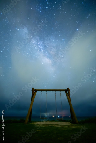 beautiful stars with the milky way and a swing in Kohamajima, Okinawa, Japan
