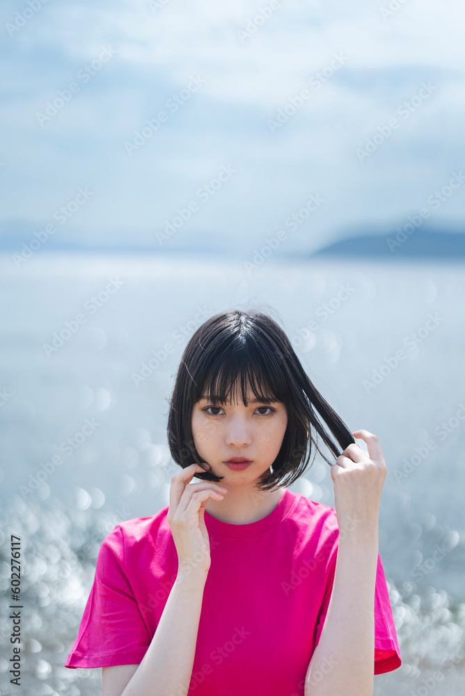 晴天の海を散策する女性