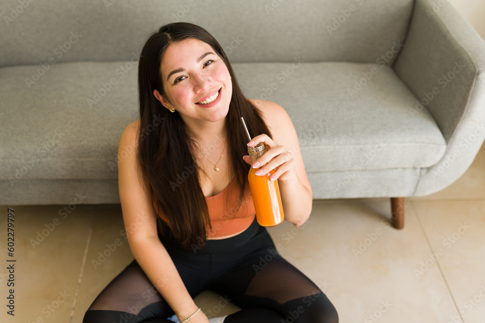 Attractive vegetarian woman drinking a carrot vegan juice Attractive vegetarian woman drinking a carrot vegan juice