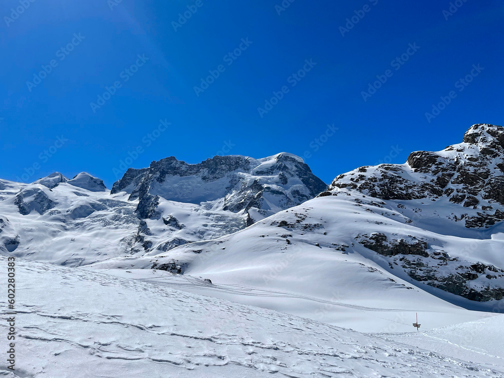 Scenic view of snow covered Swiss Alps seen from Gornergrat viewpoint on a sunny spring day. Photo taken March 23rd, Gornergrat, Zermatt, Canton Valais, 2021.