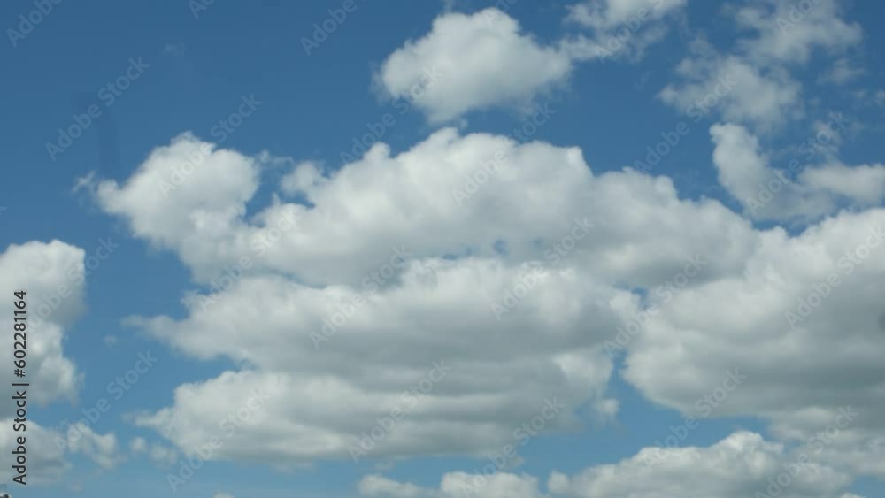 Fluffy white clouds float across the blue sky on a sunny day, time lapse Fluffy white clouds float across the blue sky on a sunny day, time lapse