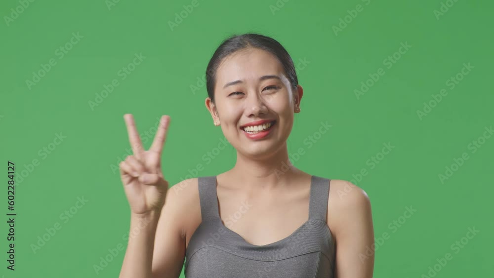 Close Up Of Asian Woman Wearing Sportswear And Showing Call Me Gesture And Smiling To Camera On Green Screen Background In The Studio
Close Up Of Asian Woman Wearing Sportswear And Showing Call Me Gesture And Smiling To Camera On Green Screen Background In The Studio