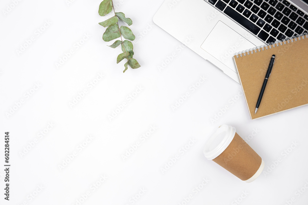 White background with laptop, notepad and disposable glass, top view