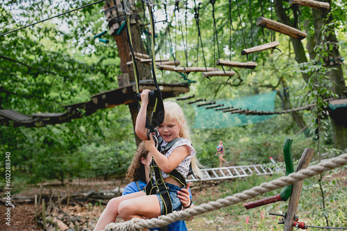 Cheerful smiling girl is engaged in climbing in the adventure park