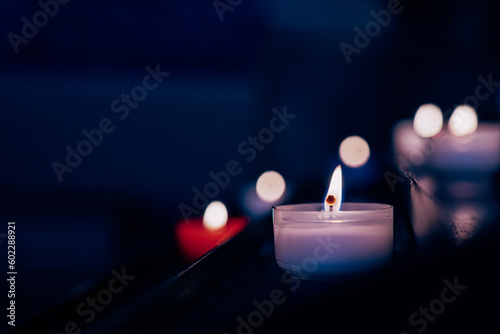 Candles in the Catholic Church. Beautiful glass windows with the evening light on the background.