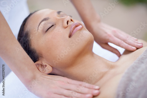 Spa, relax and woman for a massage with therapist hands on body for wellness and health. Face of a calm female client or customer on a table for peace, physical therapy and luxury zen treatment