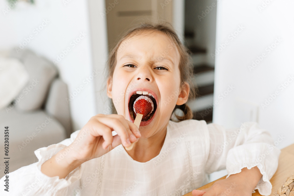 little girl eating strawberries with sugar little girl eating strawberries with sugar