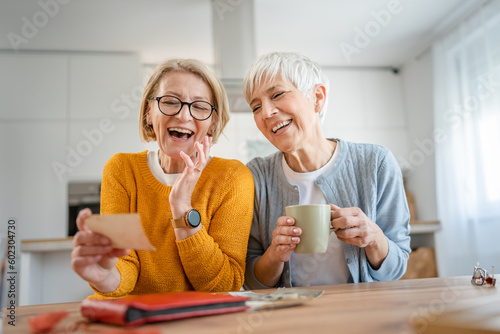 Senior mature women friends or sisters looking family photos album