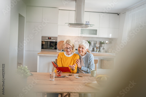 Senior mature women friends or sisters looking family photos album