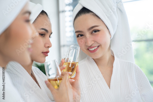 three asian female wear white bathrobe at bed room